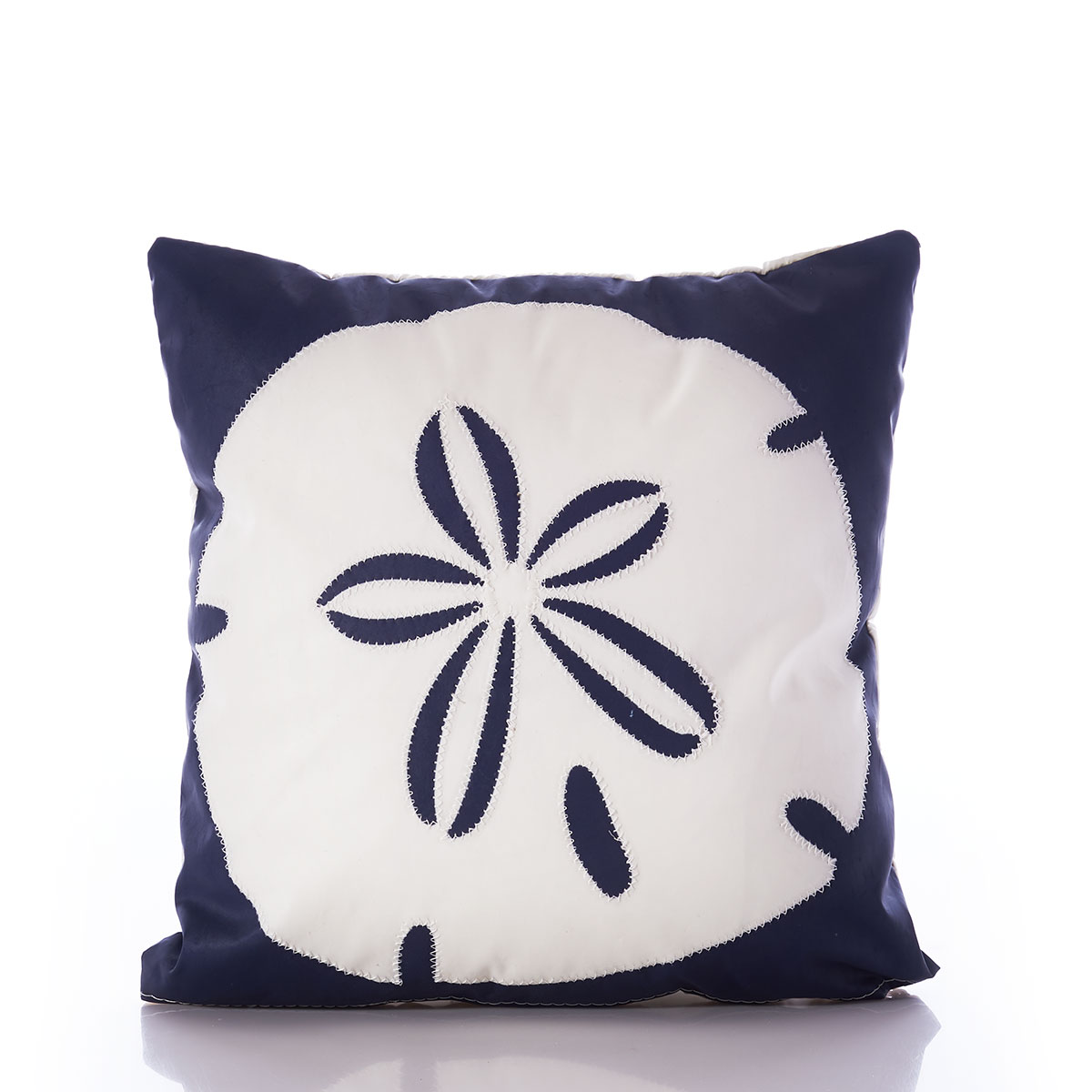 a navy recycled sail cloth pillow is embellished with a white sand dollar