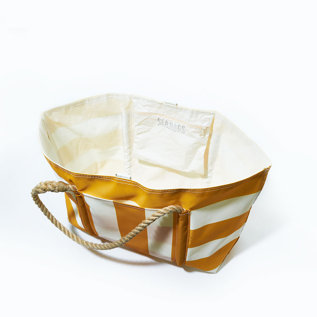 inside view: yellow and white plaid stripes adorn the front of a recycled sail cloth tote with hemp rope handles and a top metal clasp