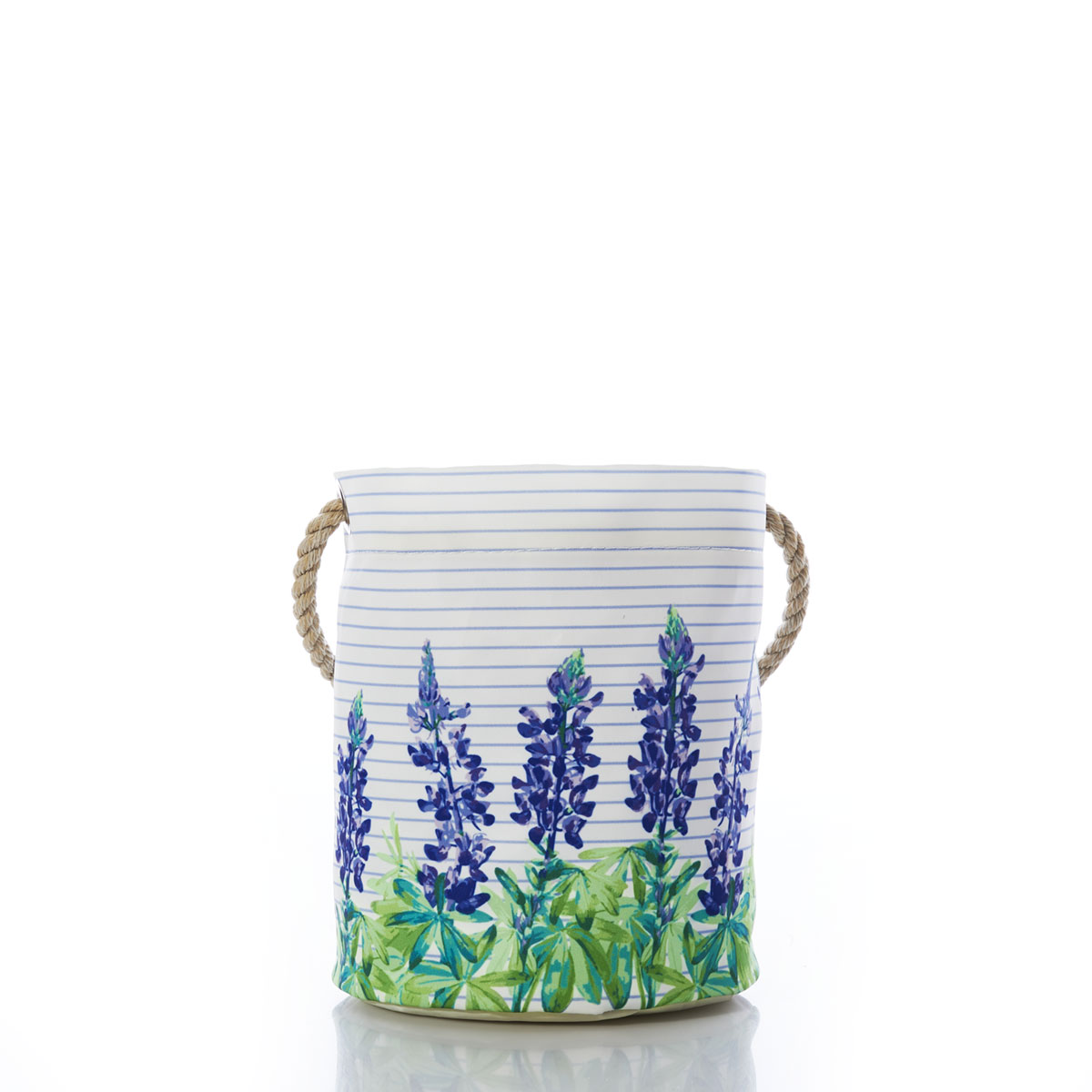 a recycled sail cloth bucket bag is printed with thin blue stripes behind a row of purple and green lupine flowers and finished with a hemp rope handle