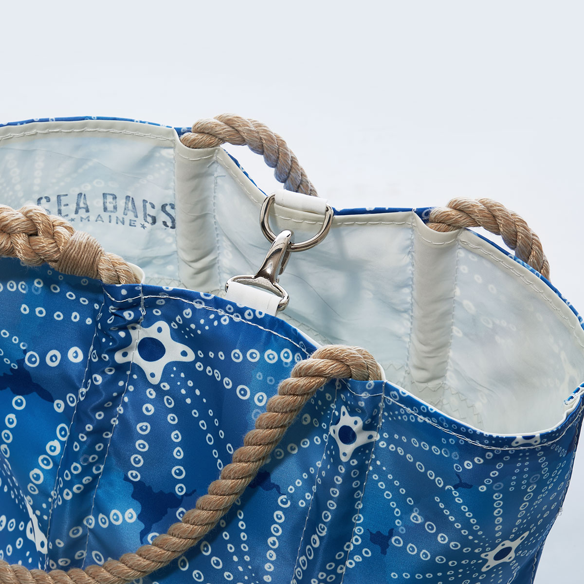 close up view of clasp closure on blue sea urchins in an all over print on recycled sail cloth handbag with hemp rope handles