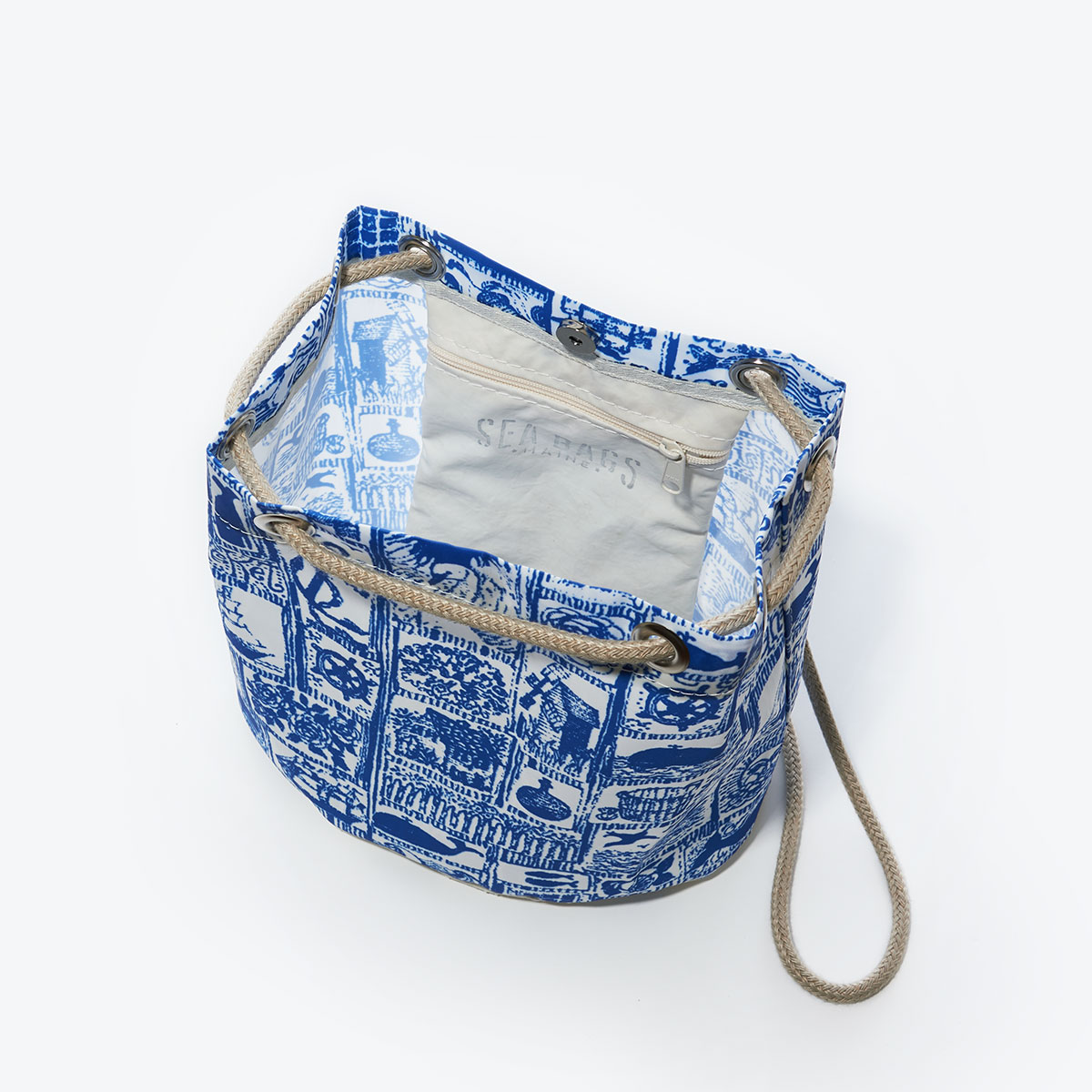 inside view of blue squares filled with various nautical imagery printed on recycled sail cloth convertible bucket bag with hemp dock line straps