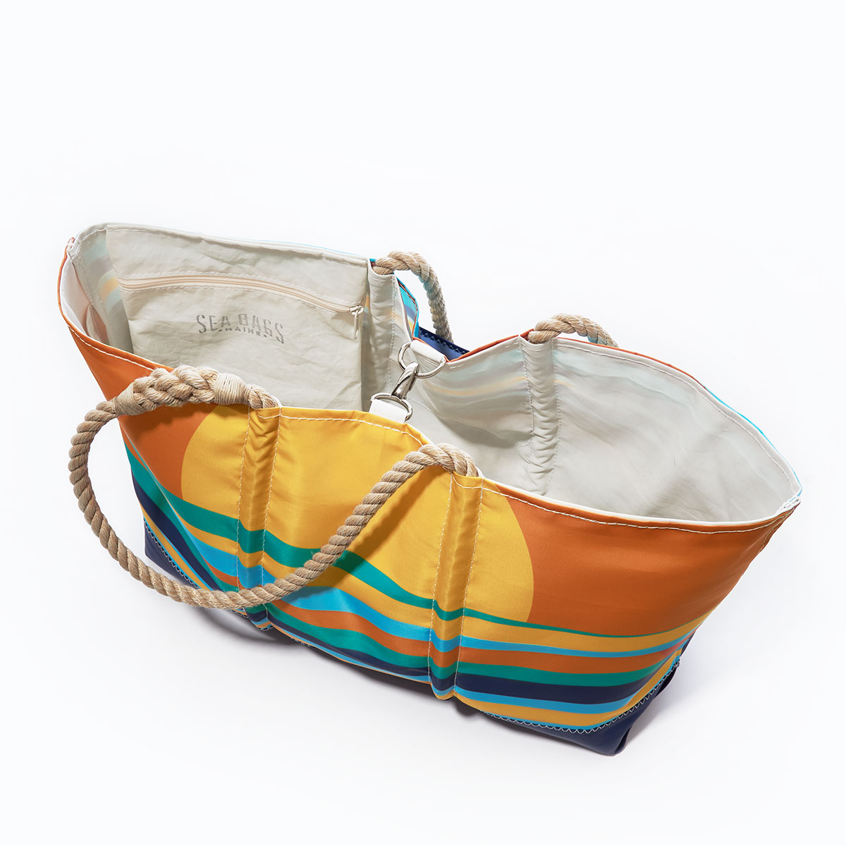 clasp closure of a tote with multicolor wavy ocean stripes sit under a rising sun printed on a recycled sail cloth tote with hemp rope handles