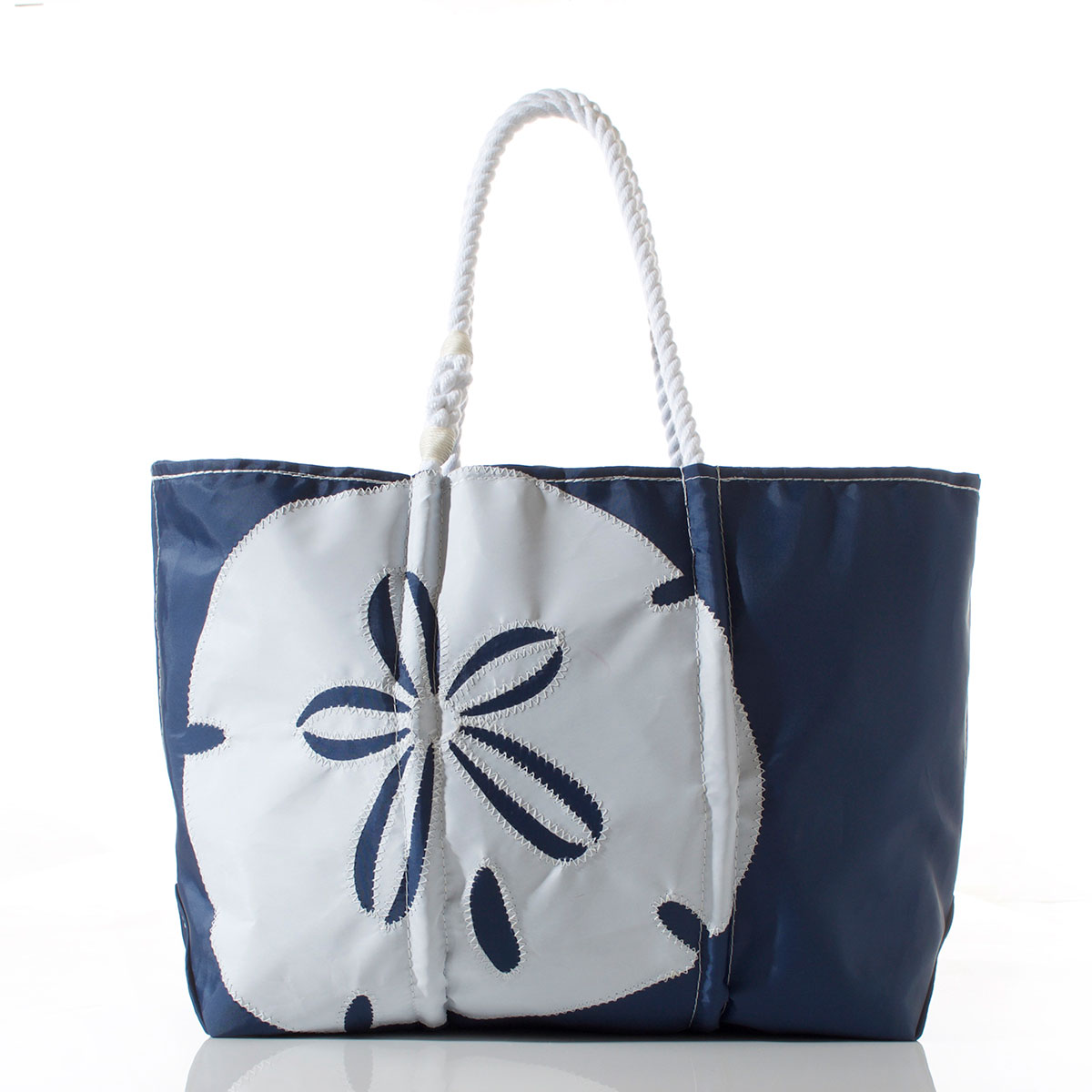 a navy recycled sail cloth tote with rope handles is embellished with a white sand dollar