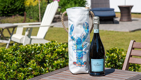 Multicolor lobster wine bag on a table with a bottle of wine outside