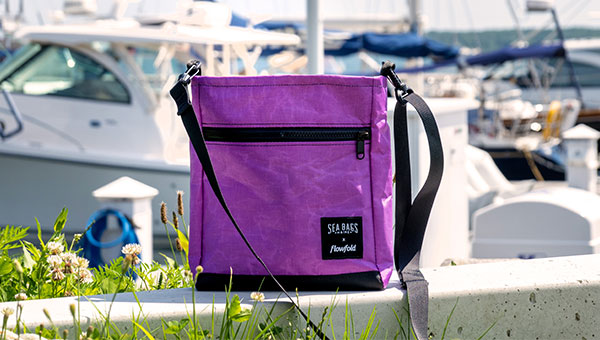 Purple Vintage Voyager crossbody on a rock outside