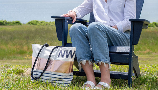 Woman sitting in a chair with a tote at her feet