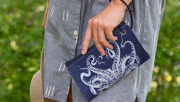 Navy octopus wristlet being held by woman in blue dress