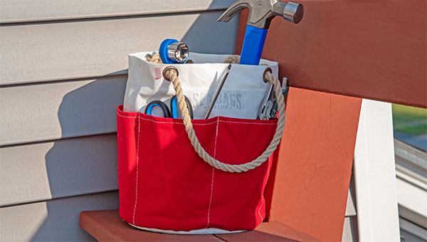 Red tool bucket on bench with tools inside it